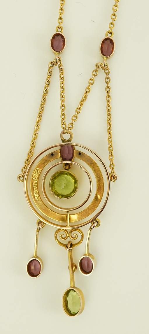 An Edwardian 9ct gold, peridot and garnet set drop pendant necklace, by Murrle Bennett & Co